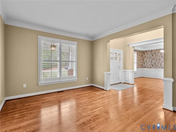 a view of a dining room and livingroom with furniture wooden floor a chandelier