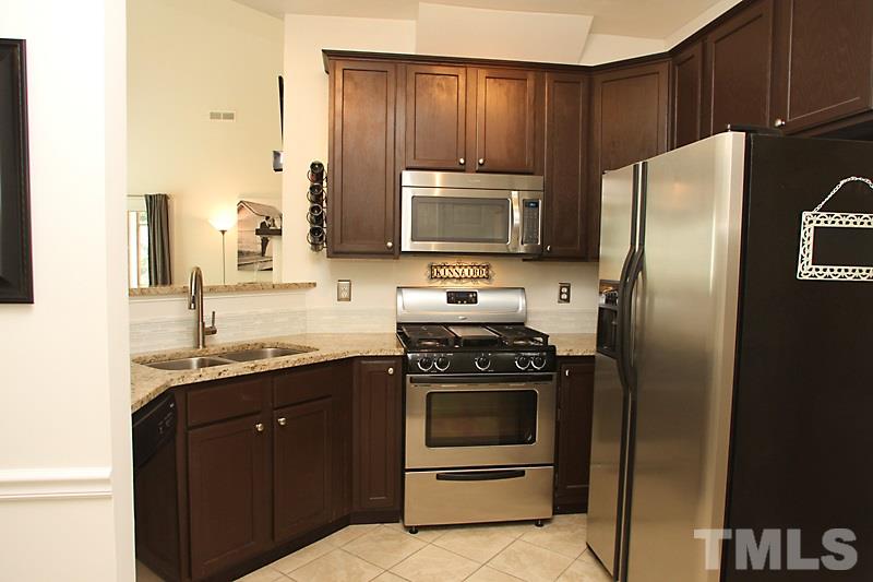 4717 Delta Ridge Court Raleigh, NC 27612 - Photo 9 of 25 Dark stained cabinets and granite counters