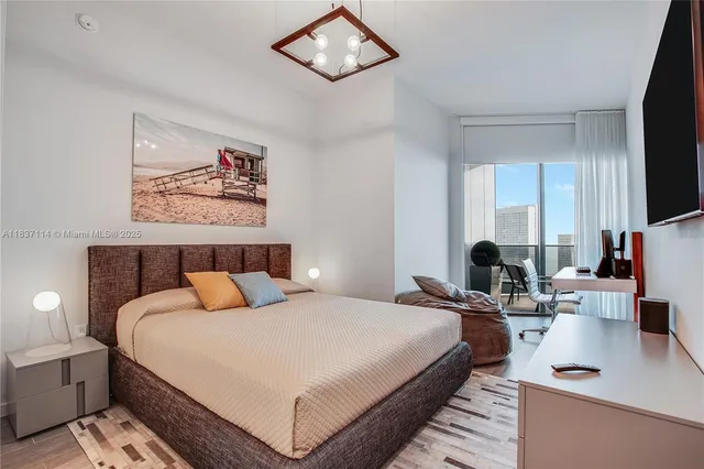 a bedroom with bed a flat tv screen and a view of bedroom