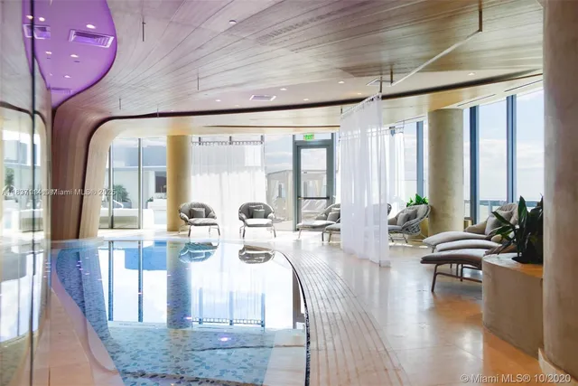 a living room with fireplace furniture and a large window