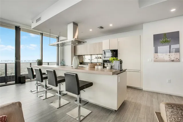 a kitchen with kitchen island granite countertop wooden floors and white cabinets