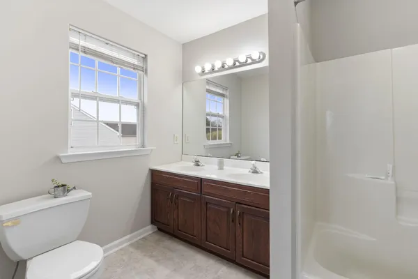 a bathroom with a double vanity sink a mirror and a bathtub
