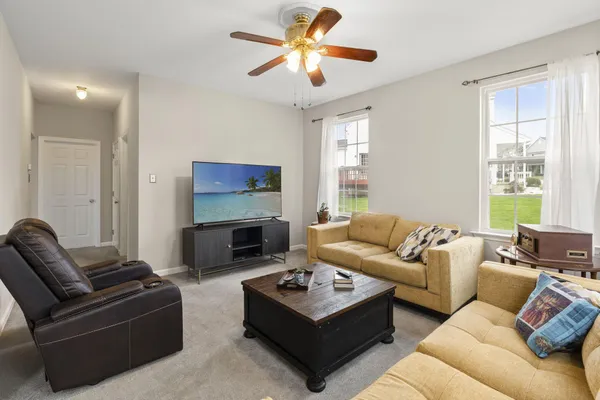 a living room with furniture a flat screen tv and a fireplace