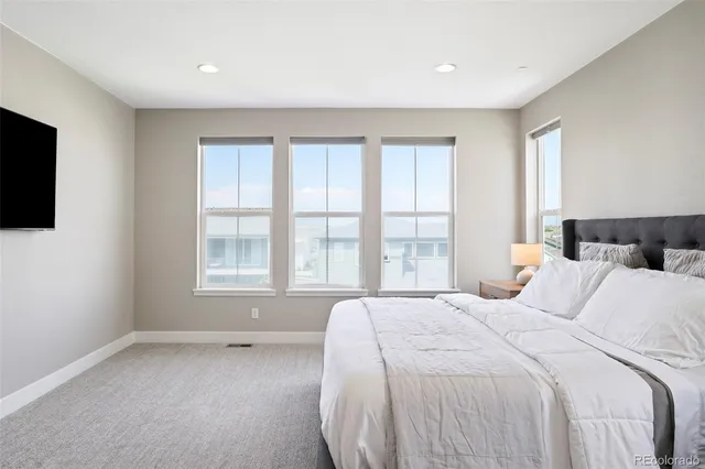 a spacious bedroom with a bed and a flat screen tv