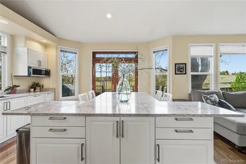 a view with granite countertop a sink and a wooden floor