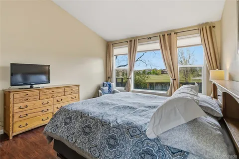 a bedroom with a bed and a flat tv screen on dresser