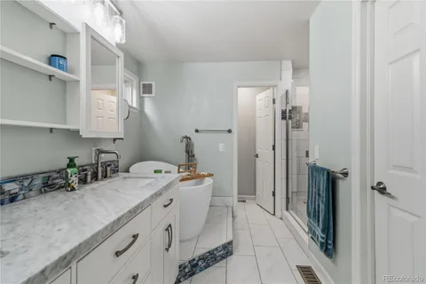 a bathroom with a tub sink and mirror