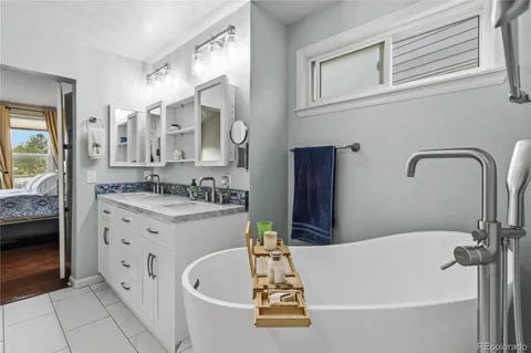 a bathroom with a tub sink and mirror