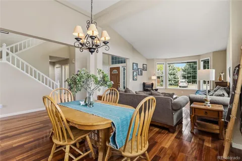a view of a dining room with furniture a chandelier and wooden floor