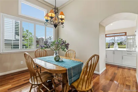 a dining room with furniture potted plants and wooden floor