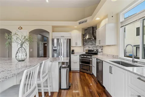 a kitchen with stainless steel appliances granite countertop a stove a sink and a refrigerator