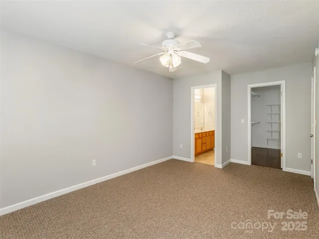 an empty room with closet and fan