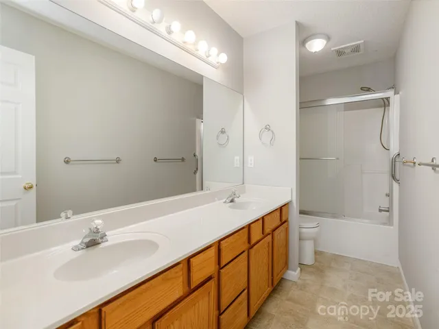 a spacious bathroom with a double vanity sink mirror double and shower