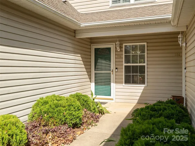 a view of a house with a window and flower plants