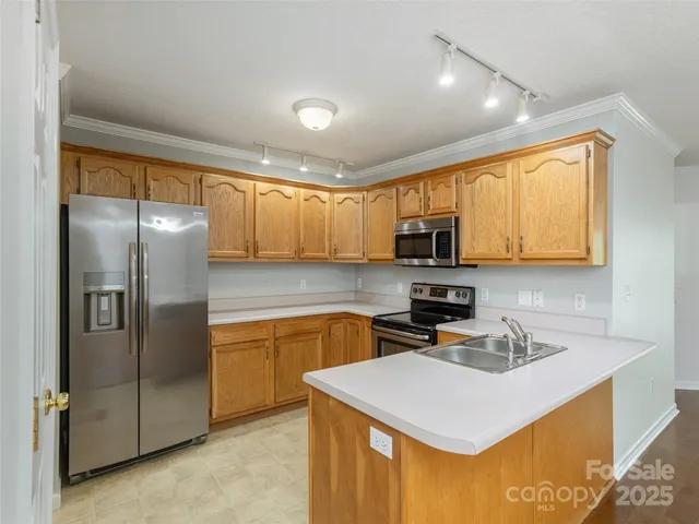 a kitchen with granite countertop a refrigerator stove top oven sink and cabinets
