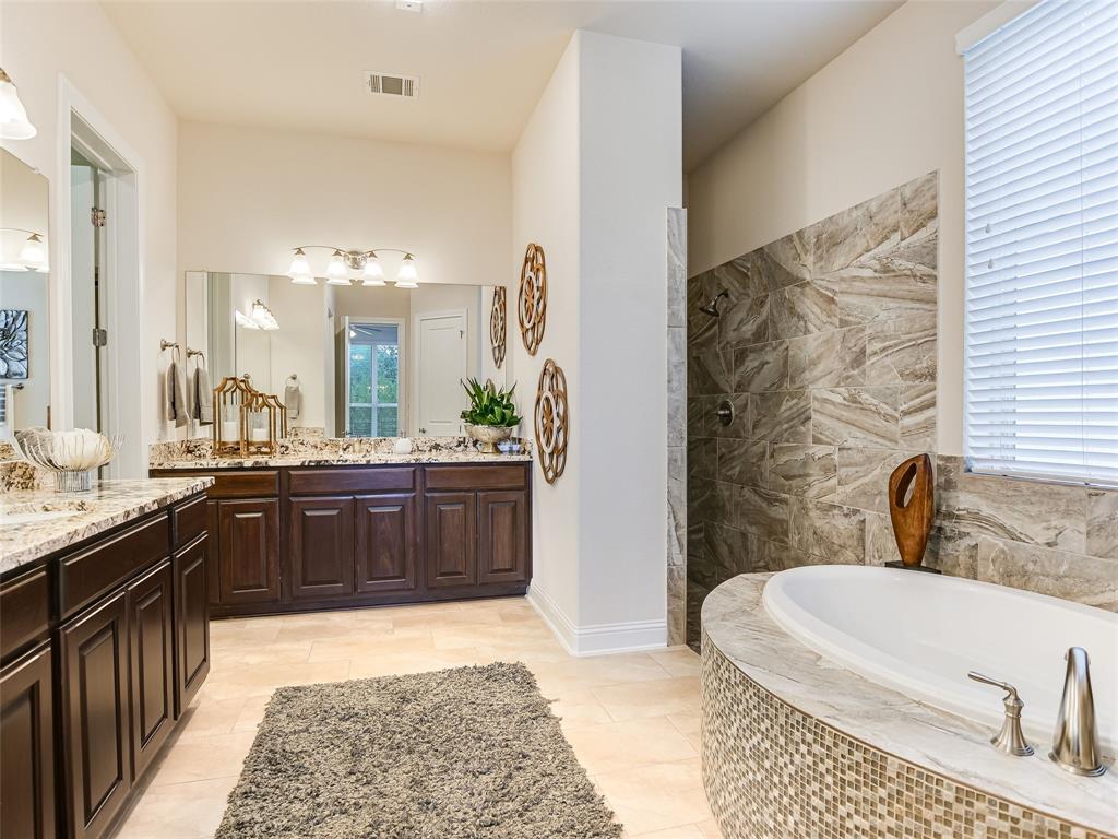 2657 Montebelluna Place Leander, TX 78641 - Photo 14 of 29 Bathroom featuring a garden tub, two vanities, walk in shower, and light tile patterned floors