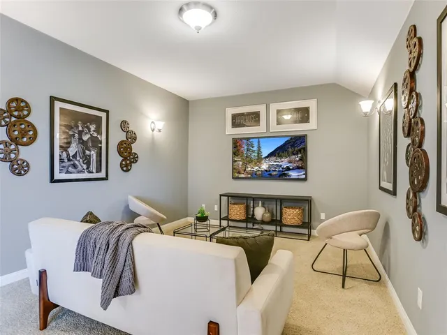 a living room with furniture and a painting on the wall