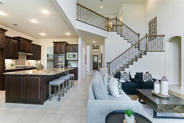 a dining hall with stainless steel appliances kitchen island granite countertop a living room view