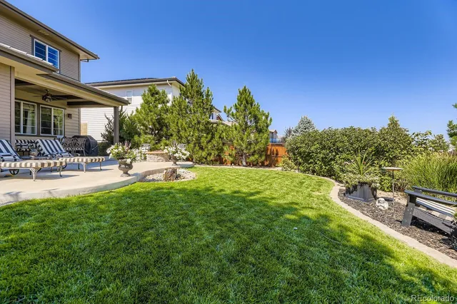 a view of a house with a yard patio and fire pit