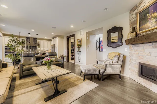 a kitchen with kitchen island granite countertop a stove a sink a oven and a refrigerator with wooden floor