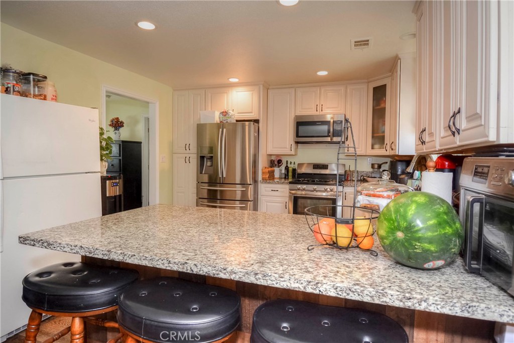 4320 Ambs Drive Riverside, CA 92505 - Photo 18 of 35 a kitchen with stainless steel appliances granite countertop a sink refrigerator and microwave
