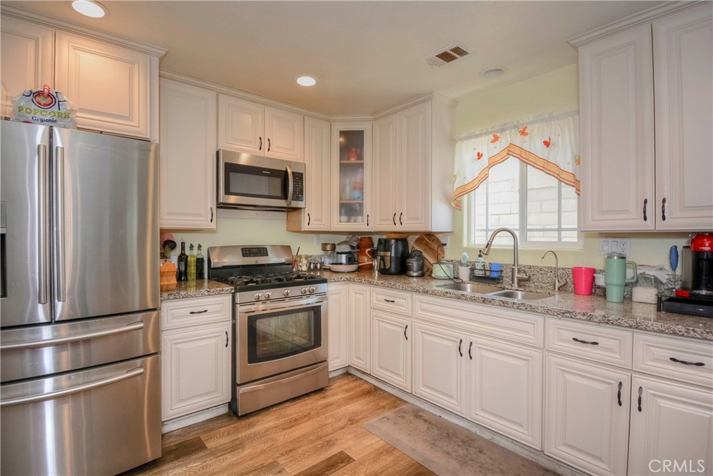 4320 Ambs Drive Riverside, CA 92505 - Photo 21 of 35 a kitchen with white cabinets stainless steel appliances and a window