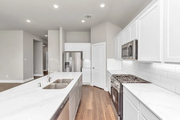 a kitchen that has a sink a stove and refrigerator