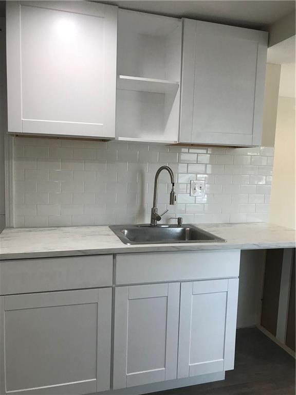 1119 Spur Street, Unit A Austin, TX 78721 - Photo 5 of 10 A well-appointed kitchen showcasing elegant white cabinetry and a practical stainless steel sink.