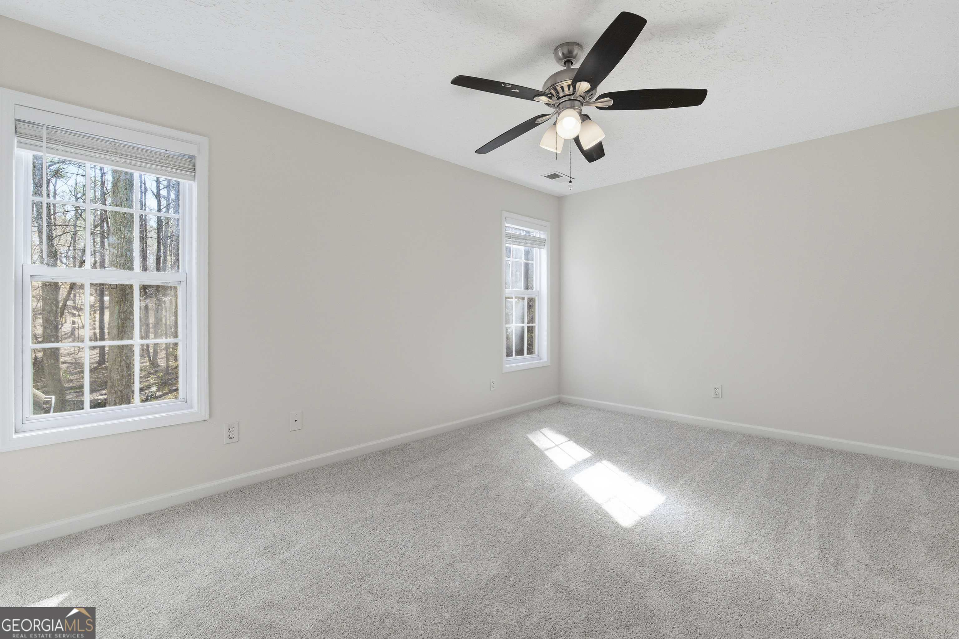 1217 Monticello Drive Villa Rica, GA 30180 - Photo 19 of 36 an empty room with windows and fan