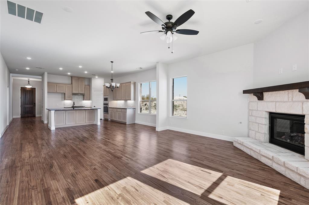 613 Brazos Drive Van Alstyne, TX 75495 - Photo 13 of 29 Unfurnished living room featuring recessed lighting, a chandelier, dark wood finished floors, a ceiling fan, and a fireplace