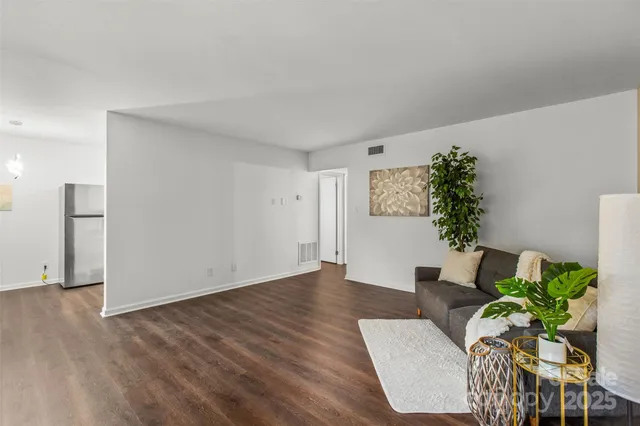 a living room with furniture and a potted plant