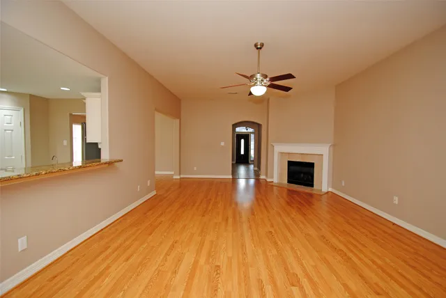 a view of livingroom with fireplace ceiling fan and hardwood floor