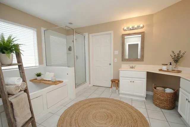 a spacious bathroom with a tub sink and mirror