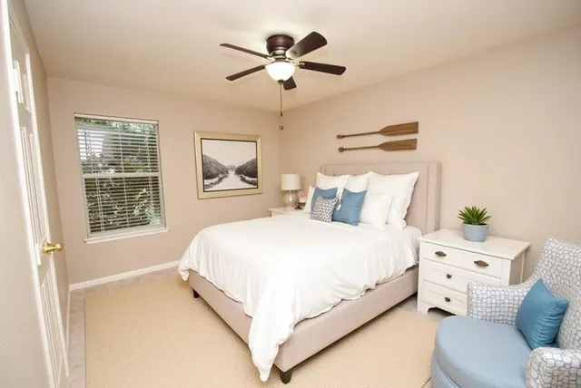 a large white bed sitting in a bedroom next to a window