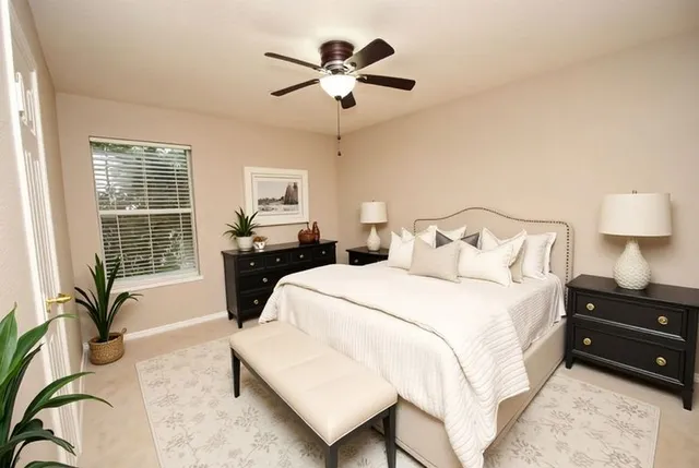 a bedroom with a bed and dresser with wooden floor