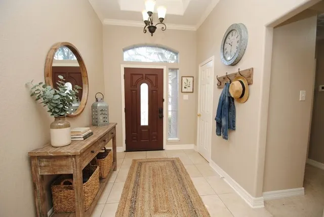 a view of a hallway with entryway wooden floor and a chandelier