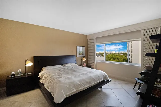 a bedroom with a bed and a large mirror