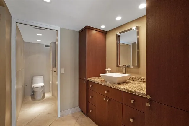 a bathroom with a granite countertop sink toilet and shower