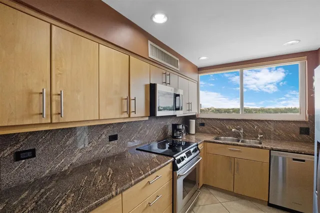 a kitchen with stainless steel appliances granite countertop a stove a microwave and a sink