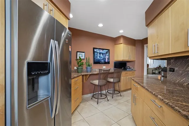 a kitchen with stainless steel appliances granite countertop a refrigerator a stove a sink dishwasher and white cabinets with wooden floor