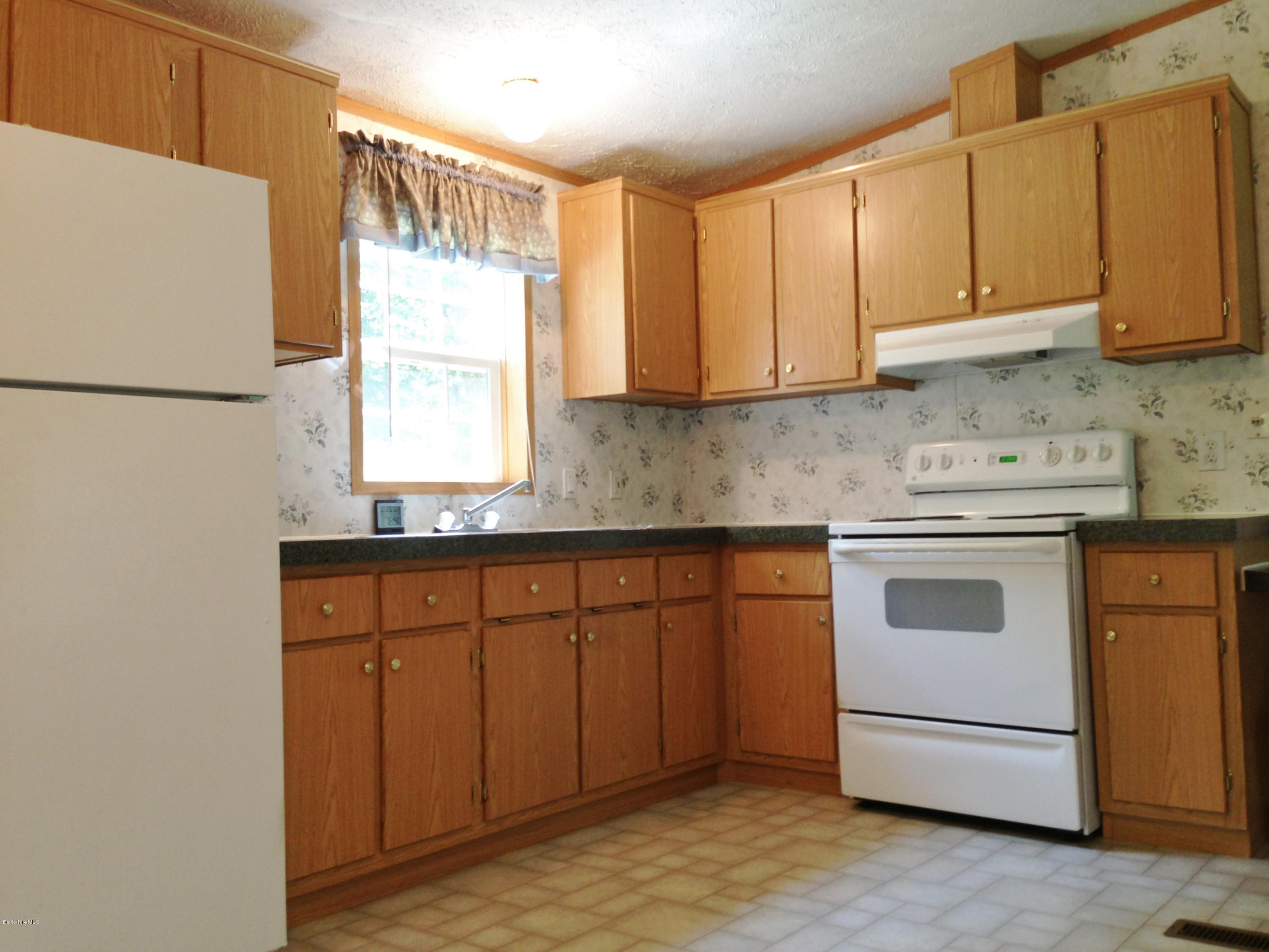 576 East Otis Road Otis, MA 01253 - Photo 8 of 13 a kitchen with granite countertop white cabinets and white appliances