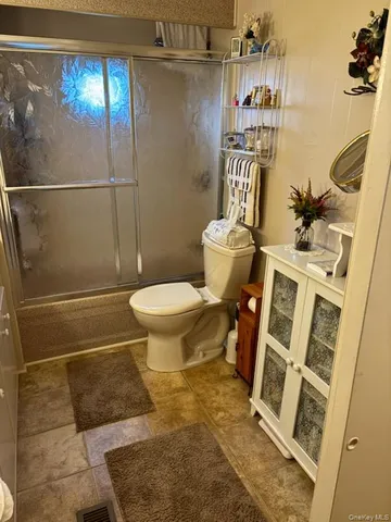 a bathroom with a toilet and a shower