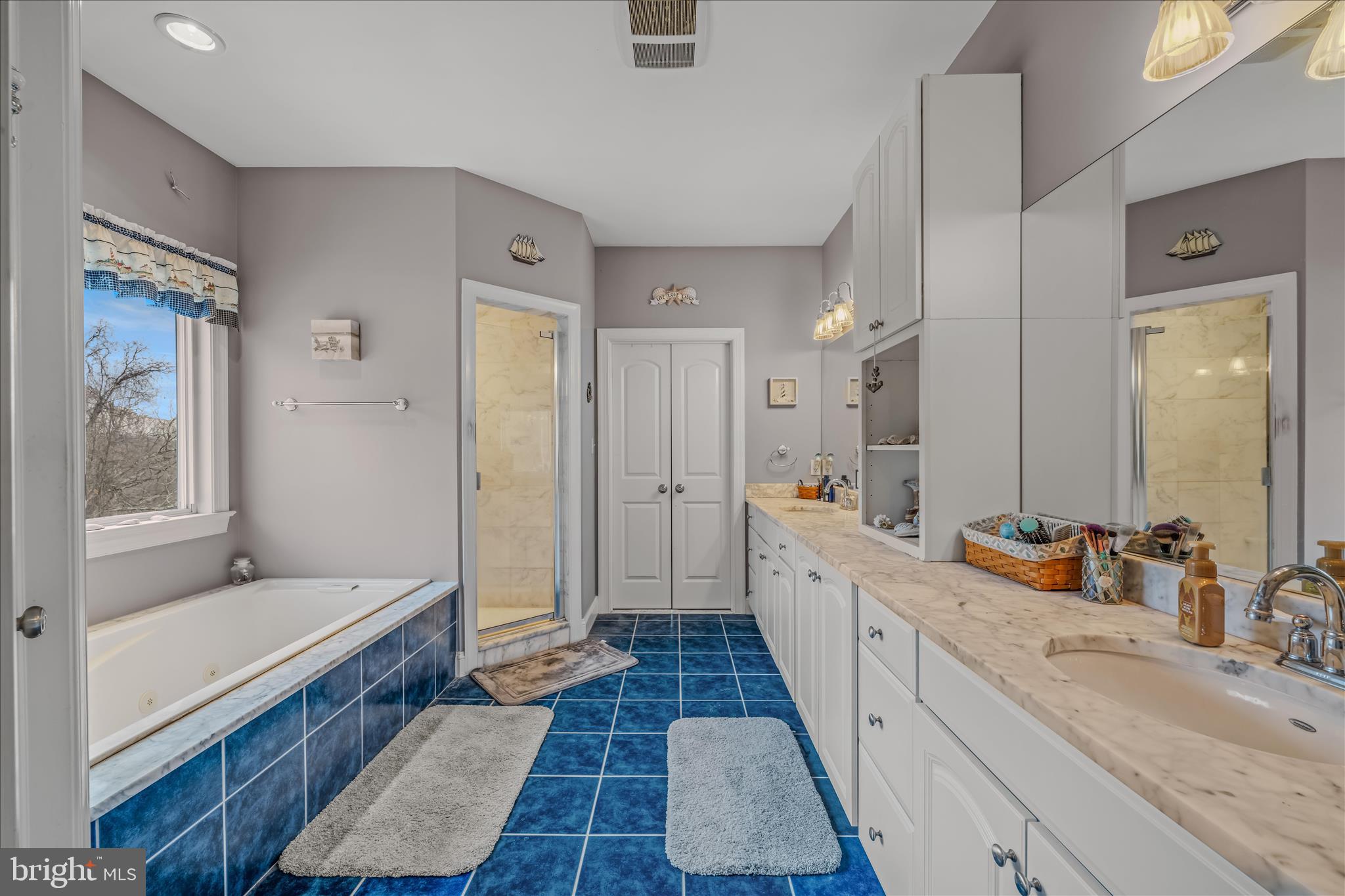 7020 Debold Road Thurmont, MD 21788 - Photo 36 of 83 a large bathroom with a double vanity sink a mirror and a shower