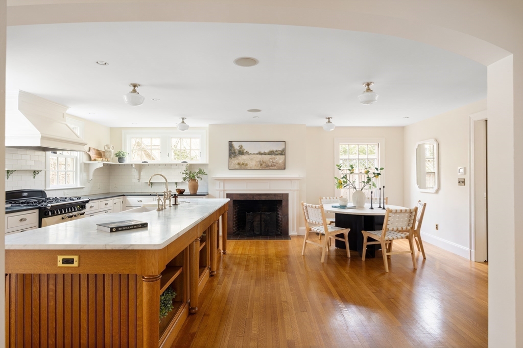 15 Hubbard Park Road Cambridge, MA 02138 - Photo 9 of 31 a kitchen with stainless steel appliances granite countertop a stove top oven a sink a dining table and chairs with wooden floor