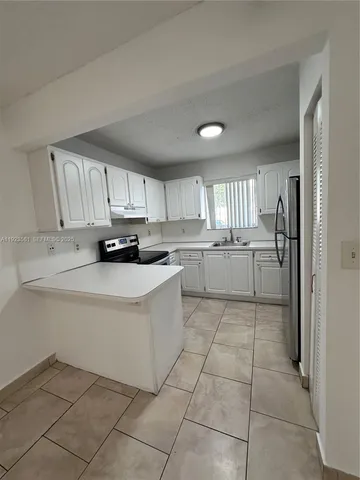 a kitchen with stainless steel appliances a refrigerator sink and cabinets
