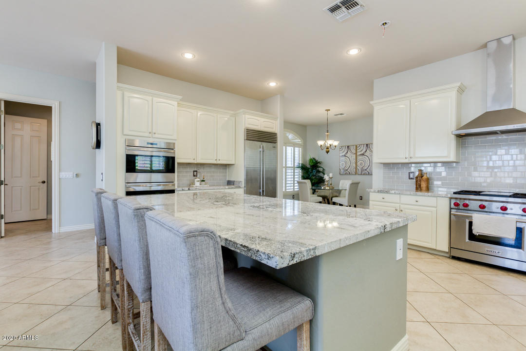 4640 East Reins Road Gilbert, AZ 85297 - Photo 17 of 122 a kitchen with stainless steel appliances granite countertop a kitchen island hardwood floor sink and stove