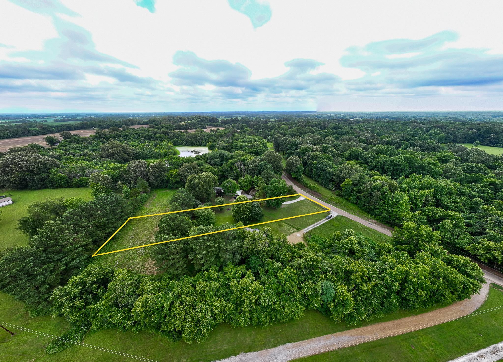 Aerial overview of property's location featuring property boundaries highlighted and a heavily wooded area