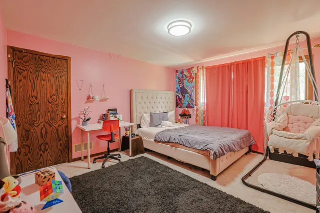 a bedroom with a bed and a painting on the wall