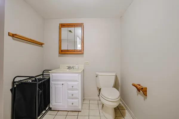 a bathroom with a toilet a sink and wooden floor
