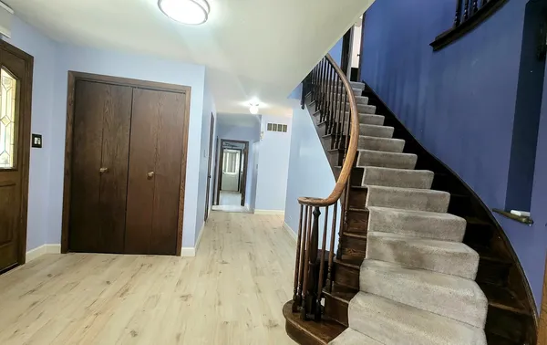 a view of hallway with wooden floor and stairs